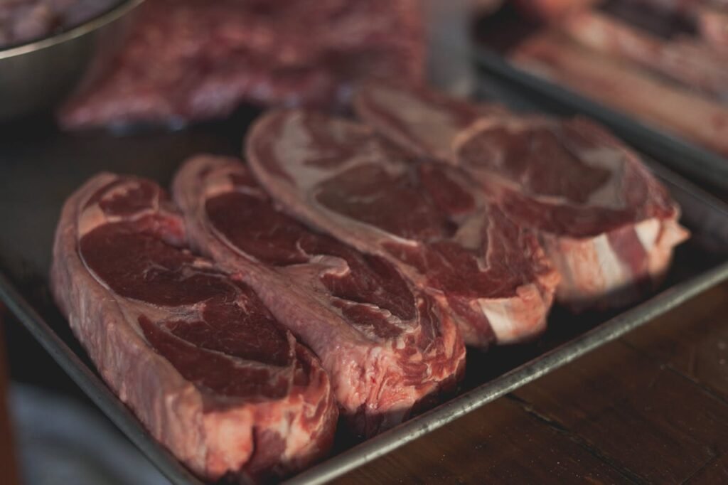 pexels-photo-8477074 High-quality close-up image of raw steaks ready for cooking on a metal tray.
